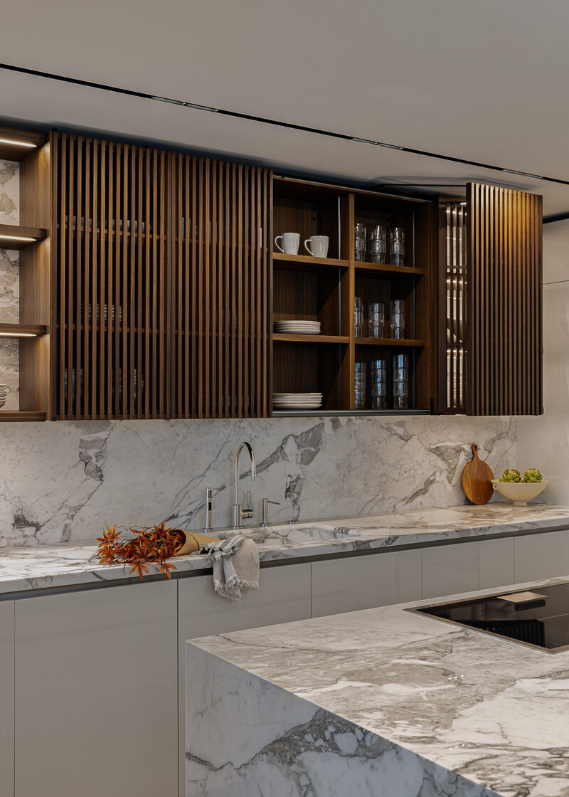 Wide shot of custom handmade kitchen cabinetry with recessed lighting, natural stone and warm wood tones, designed by Sister Studio.