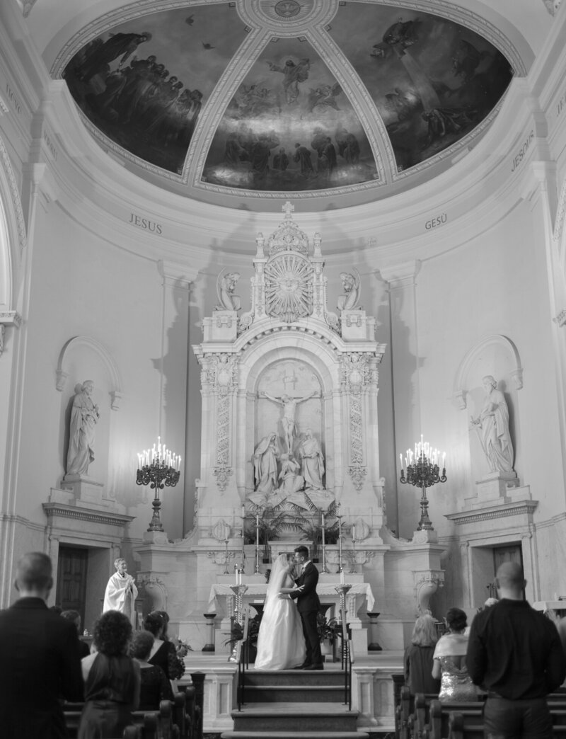 A couple's first kiss among stunning ornate architecture at their Detroit Wedding, St. Peter and Paul cathedral