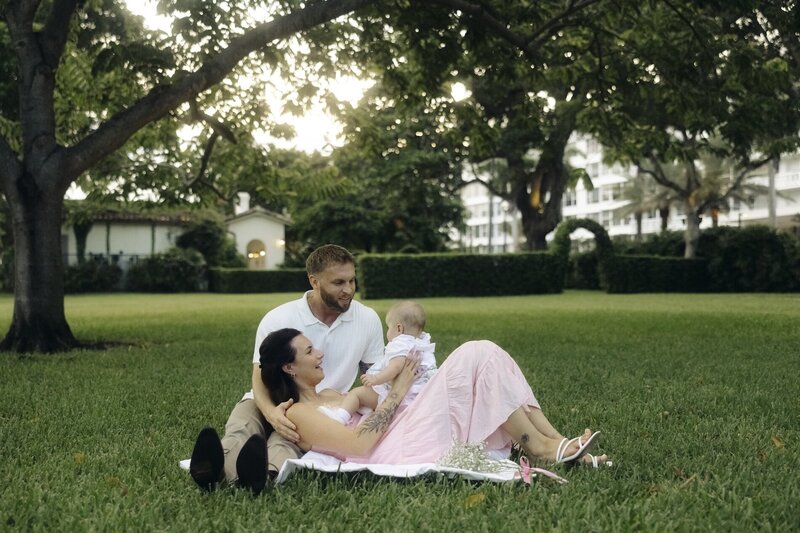 family cuddles daughter in yard