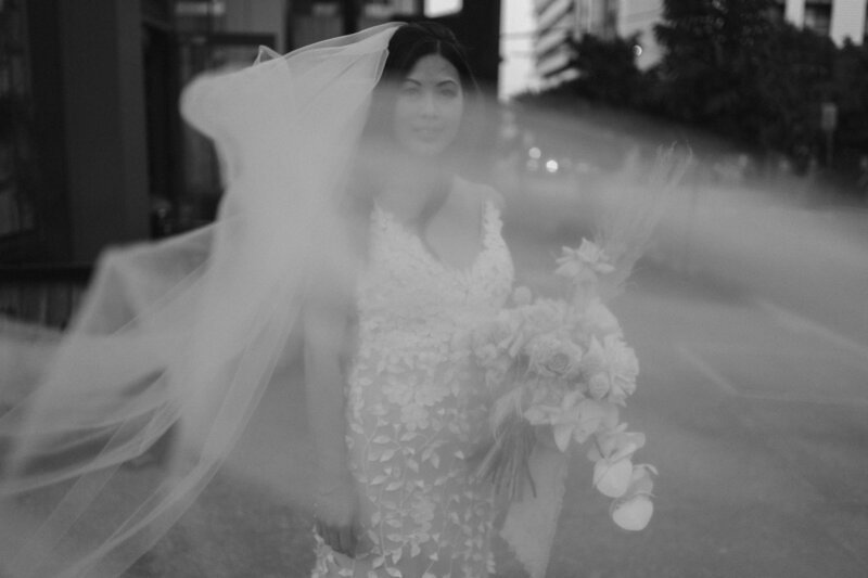 A brides veil fly's over her face in the streets of Brisbane City