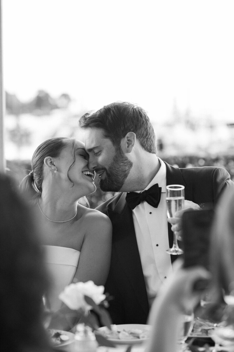 Bride and groom smiling as they kiss during their Greenwich Waterfront wedding reception