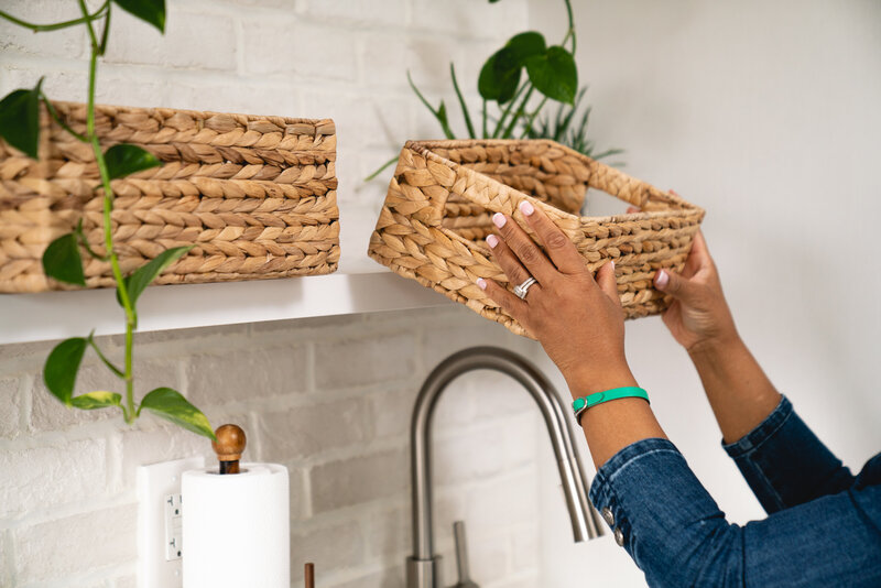 Michelle putting a small basket onto a wall shelf