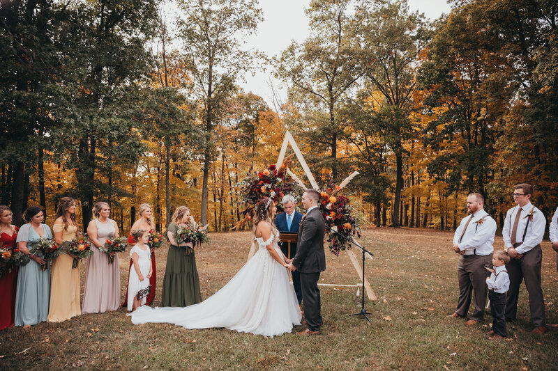 Wide angle wedding photo session during outdoor ceremony in woods