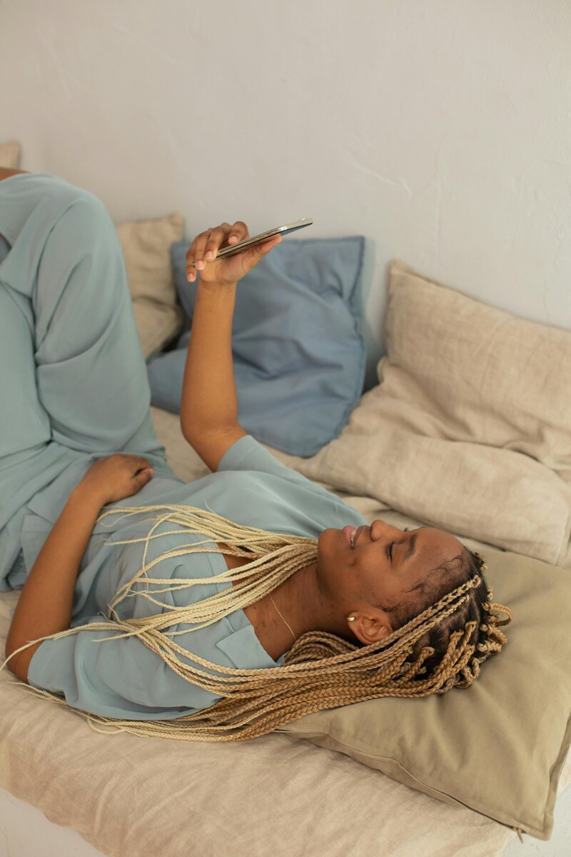 woman laying on couch on a video call on a phone