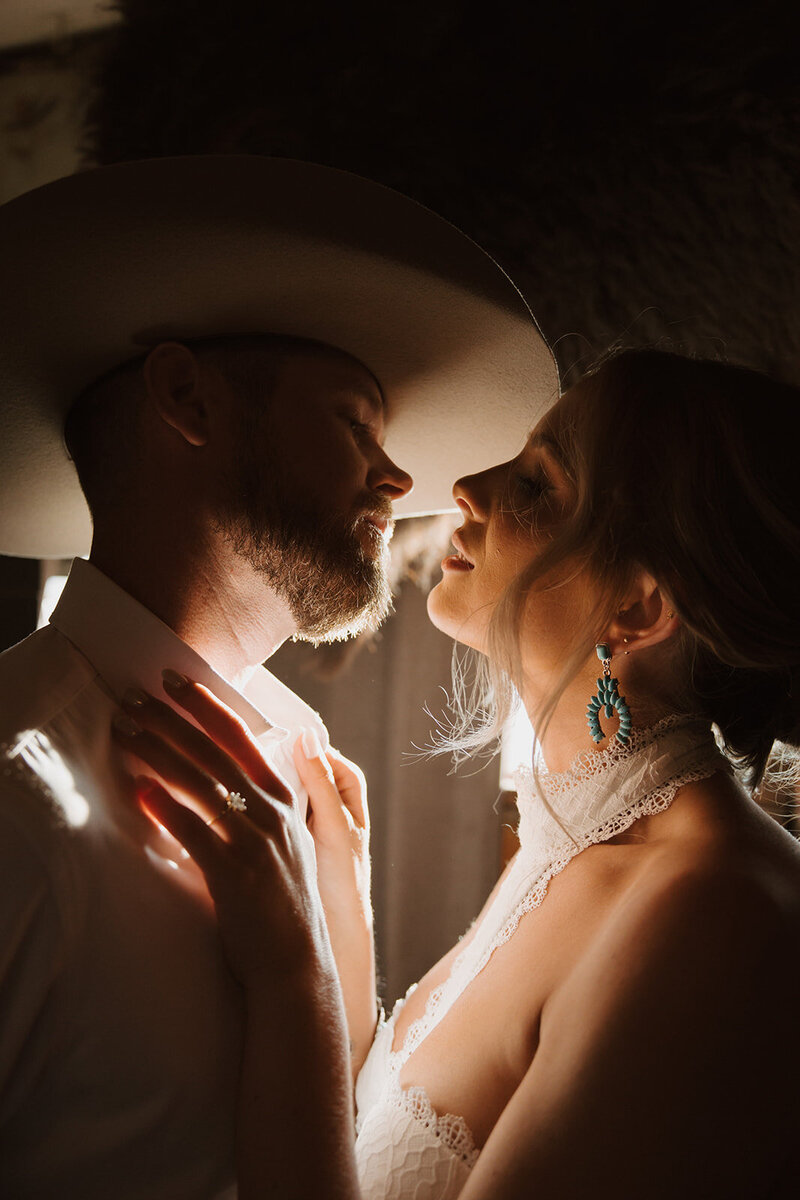 couple going in for a kiss groom wearing a cowboy hat