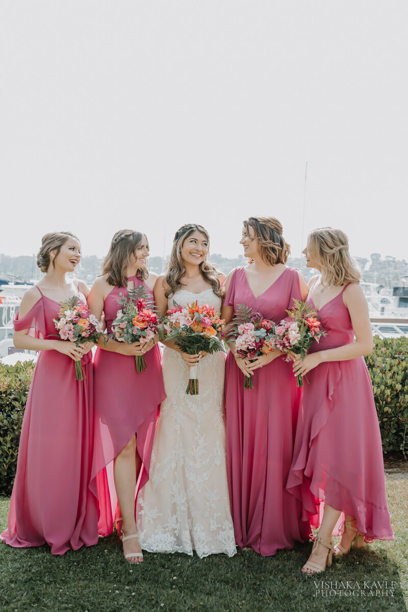 bride smiling while standing with her bridesmaids