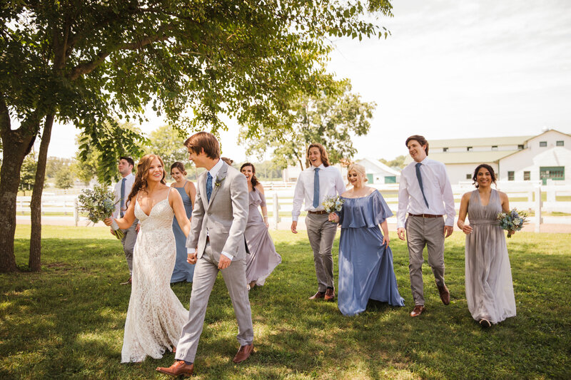 bride and groom walking with bridal party outdoors