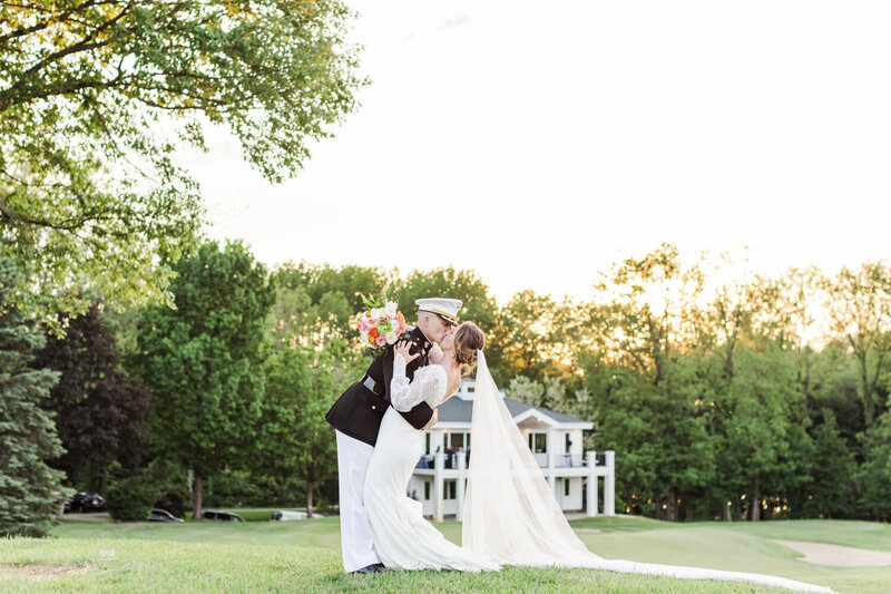 groom in a military uniform kissing bride