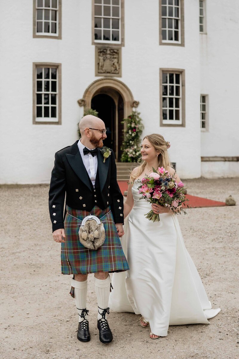 A wedding portrait of a bride and groom on the banks of the River Dee.