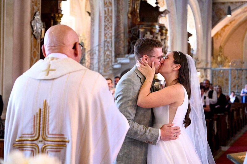 Brautpaar küsst sich vor Altar in Klosterkirche Sankt Peter & Paul hochzeit Straubing-Bogen