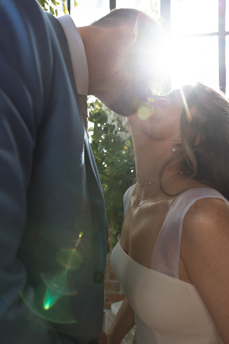 Newlywed couple share a kiss bathed in sunlight in Nashville, TN.