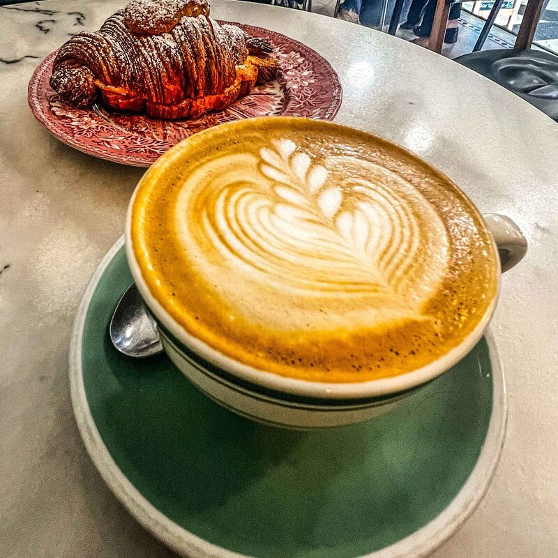 Croissant and latte in a green cup