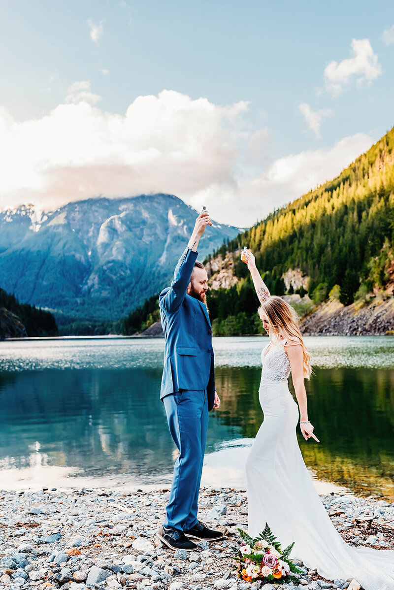 an elopement couple taking a shot in the Northern Cascade mountains with Diablo Lake in the background