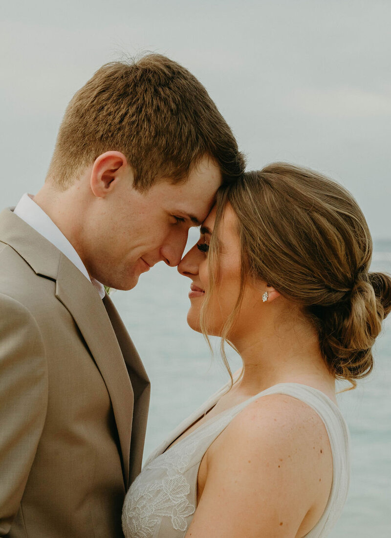 Intimate elopement moment of a couple sharing a head-to-head embrace on a beautiful beach in Ocho Rios, Jamaica, at Beaches Resort.