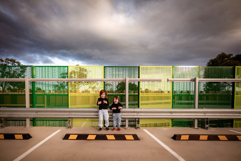 Two brothers photographed at roof to carpark with vibrant colours and an epic sky