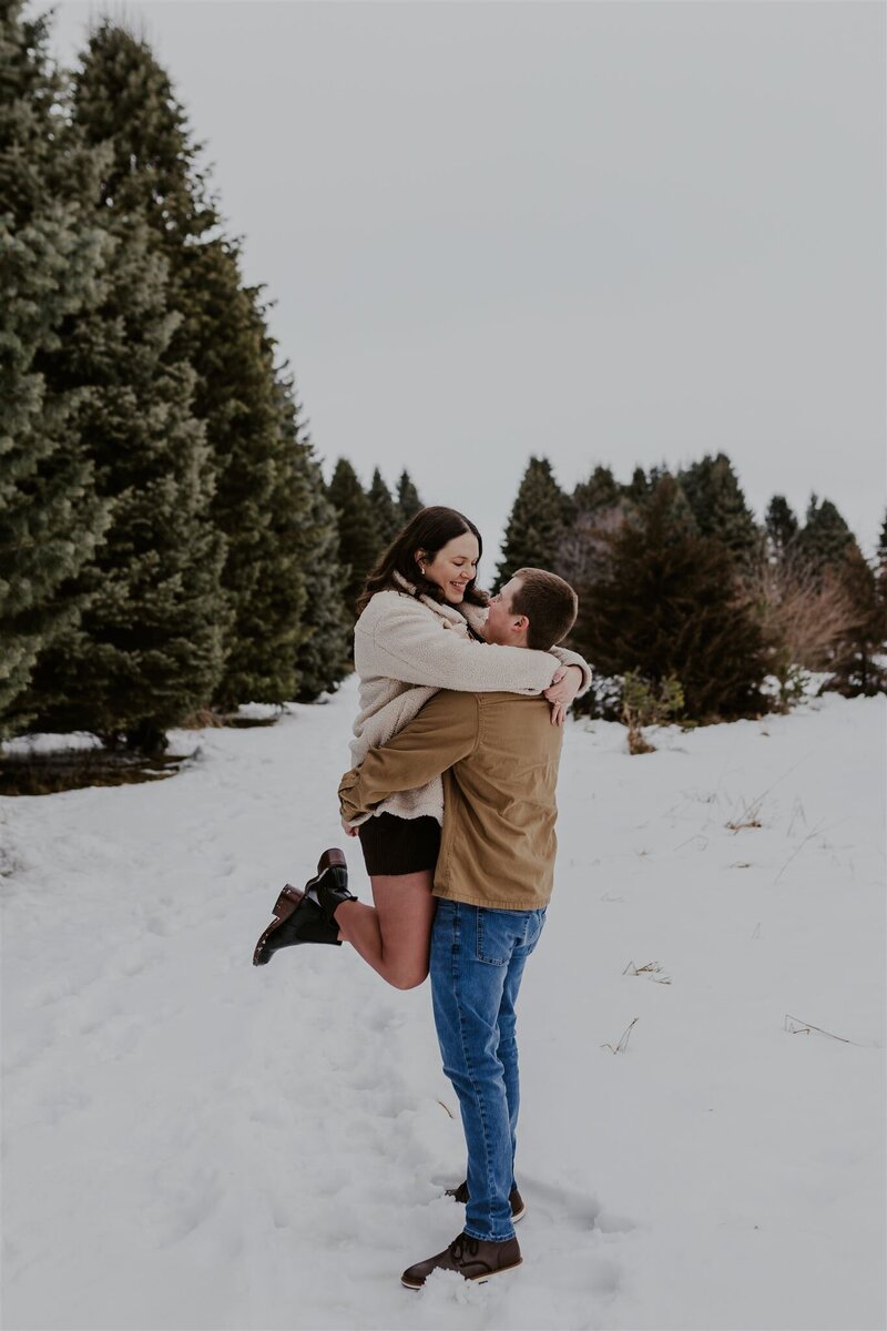 photo of man holding a woman while they both are outside in the snow taken by Lifestyle photographer Madison WI