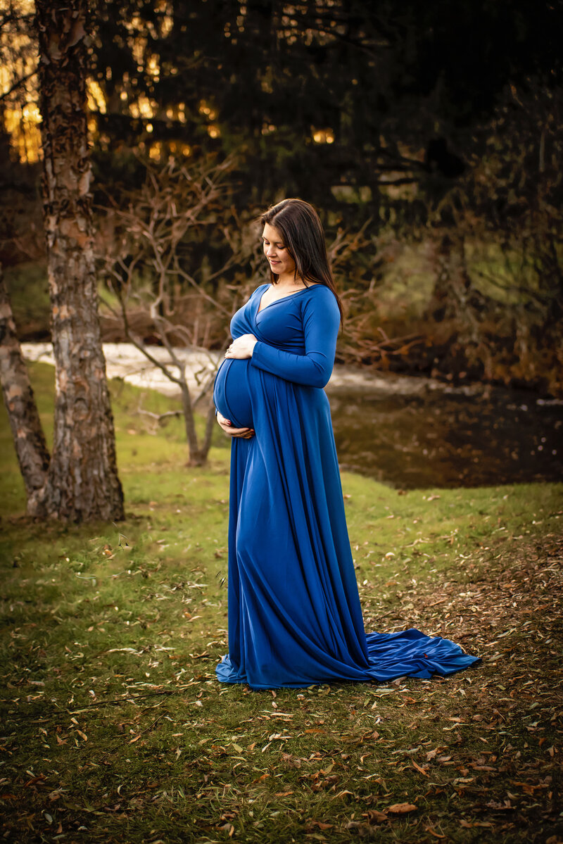 Mom dressed in blue during her Maternity session.  Happily holding her belly bump 