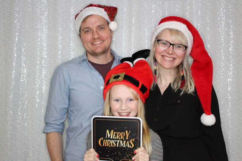 Family at Christmas party posing with photo booth props