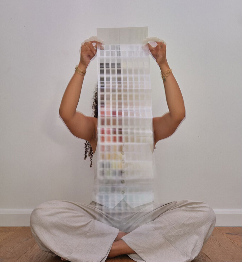 Woman sat on the floor with colour swatches over face