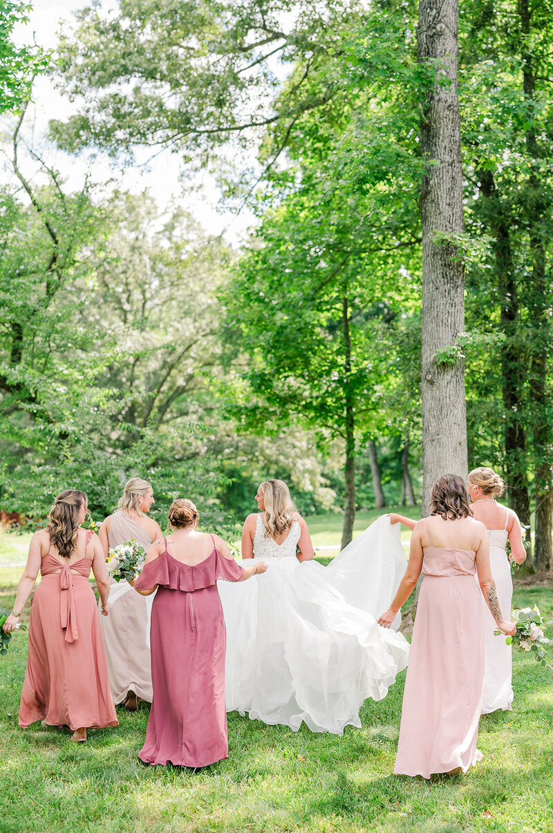 bridesmaids helping a bride with her train