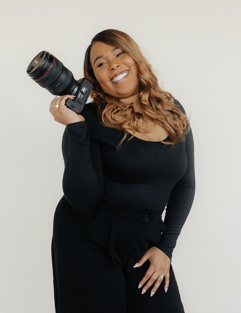 A photographer posing while holding her camera.