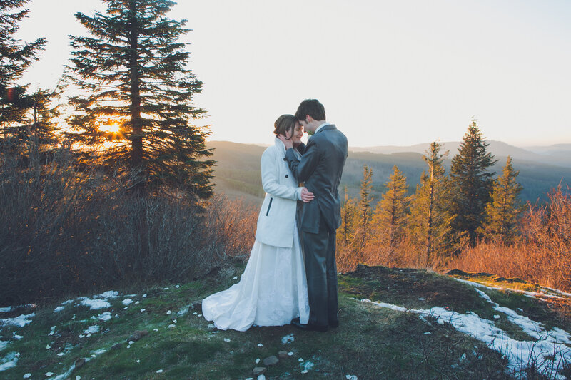 a wedding couple hug with a backdrop view of hills and mountains