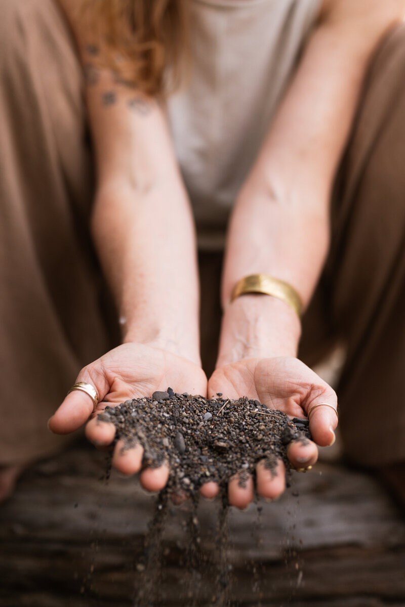 yoga teachers hands cupping dirt