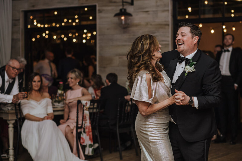 A person dancing with their parent at their wedding reception