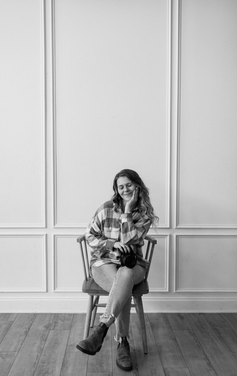 Photographer headshot holding film camera at The Claremore in Tyler, Texas in black and white.