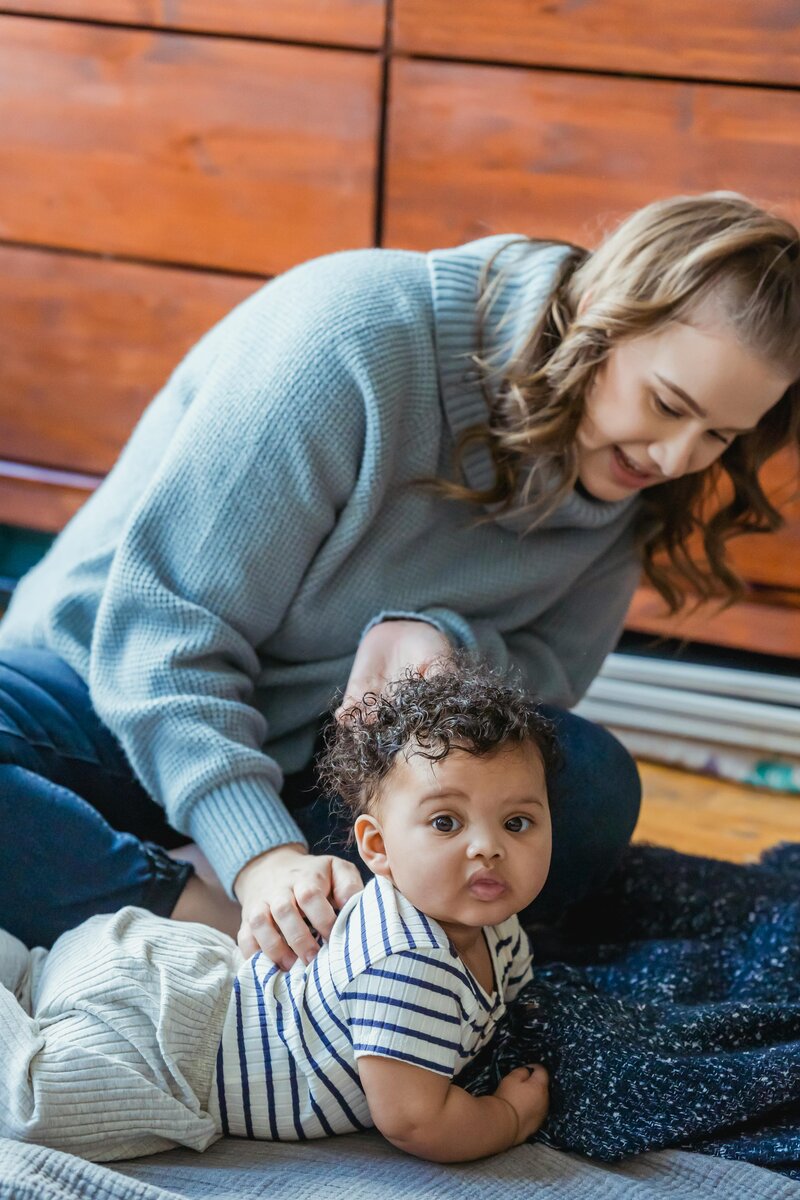  A new mom sits on a rug with her baby, enjoying a moment of bonding and support in Illinois.