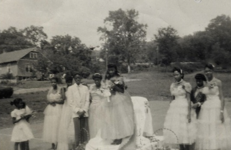 A group of young Black girls in white dresses gather for a community celebration—capturing a moment of presence, pride, and legacy often left out of official histories