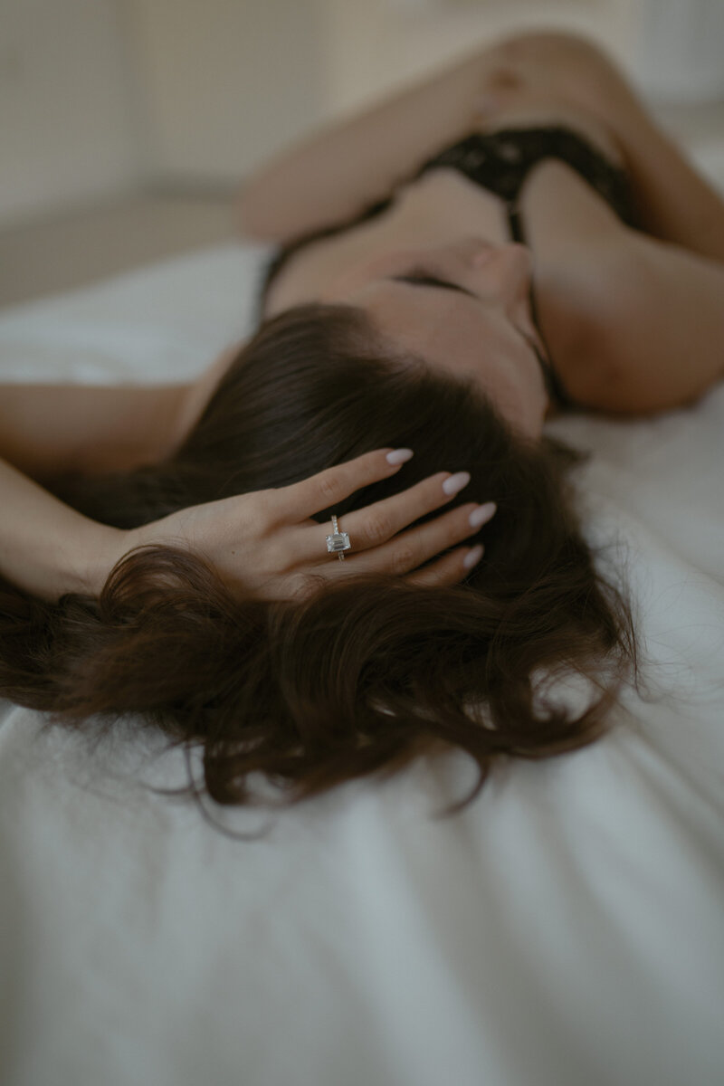 woman in lingerie sitting on floor with her head thrown back