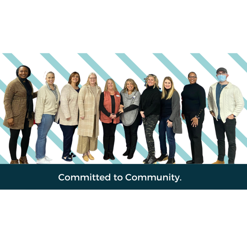 A group of 10 people standing next to each other "Committed to Community"