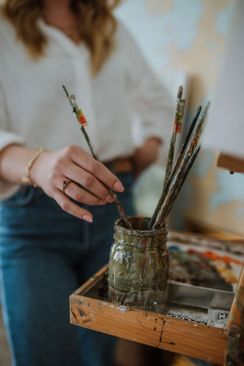 woman grabbing paint brush