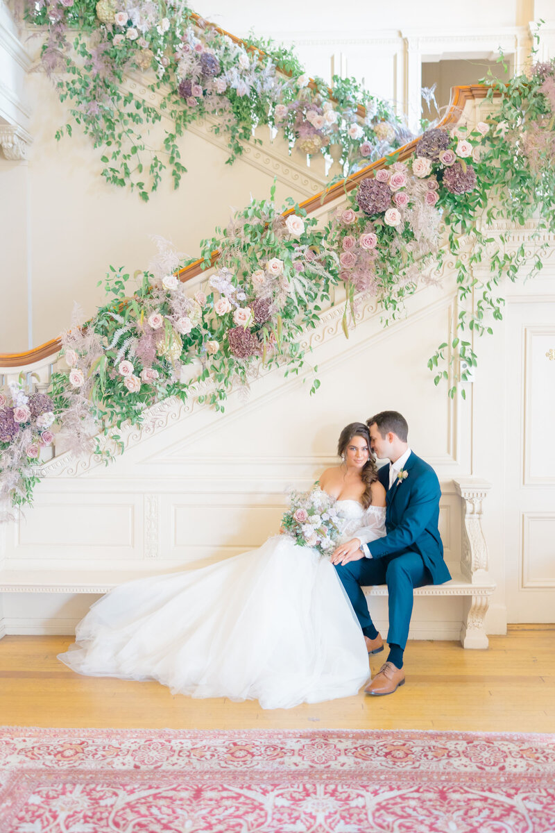 Bride and groom stand together with elegant florals at the Cairnwood Estate