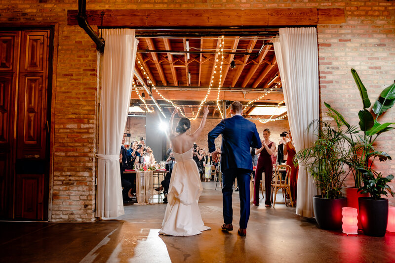 Couple enters their reception space  at The Arbory in Chicago, IL.