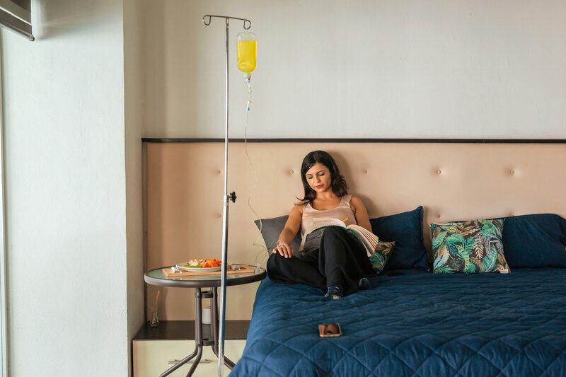 Woman receiving IV therapy from the comfort of her bed