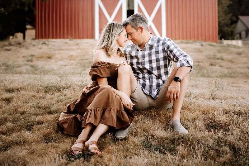 husband and wife in front of barn, petal and pup dress