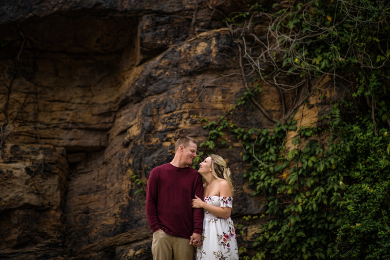 A couple sharing a playful and joyful laugh while looking at each other during their engagement session in Phoenixville, surrounded by local charm.