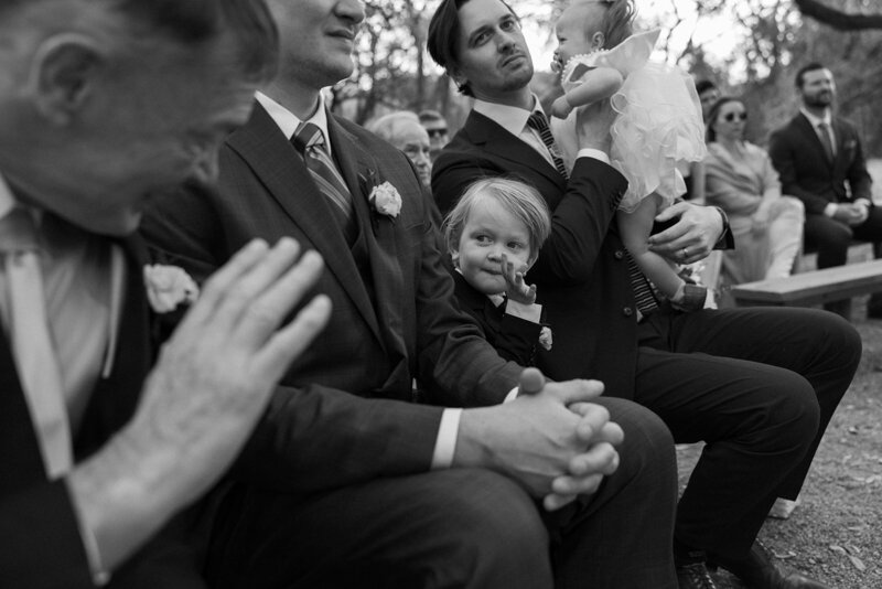 A grand father waving to his grandson while his daughter is marrying the love of her life capturing this perfect documentary moment.