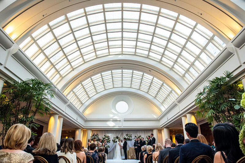 San Francisco wedding photographer captures ceremony in Palace Hotel's historic Sun Court with barrel vault glass ceiling