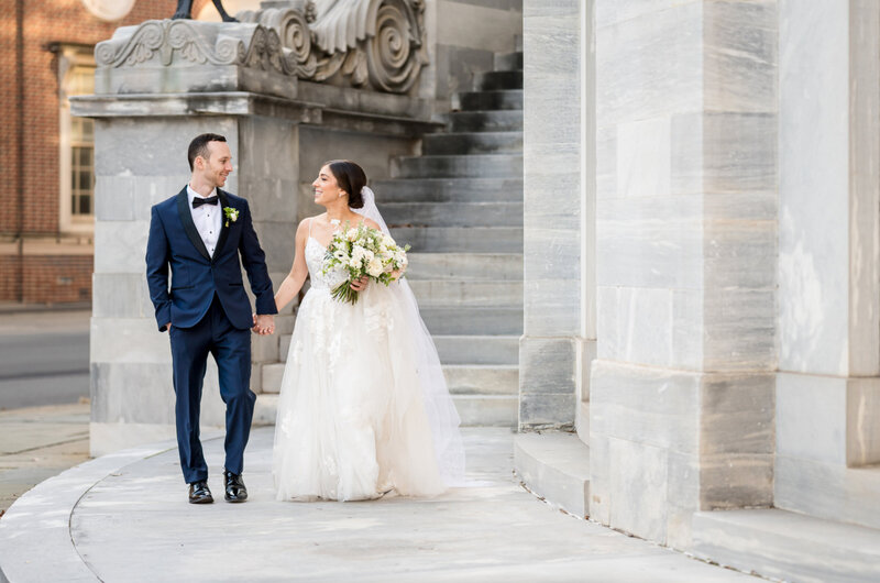 Wedding photo of a bride and groom in front of the Merchants Exchange Building in Philadelphia