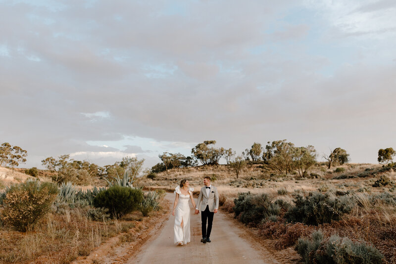 Rustic scene of bride and groom walking during wedding photography session