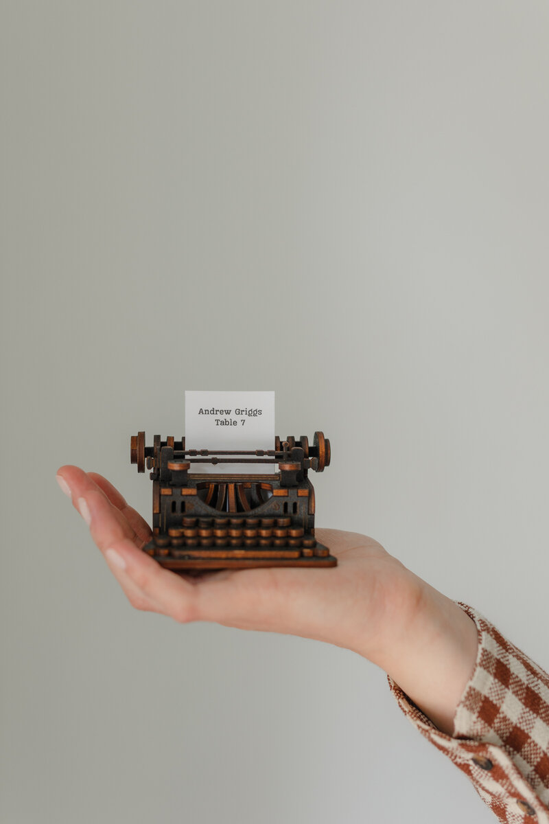 unique-escort-card-being-held-by-wedding-stationery-designer
