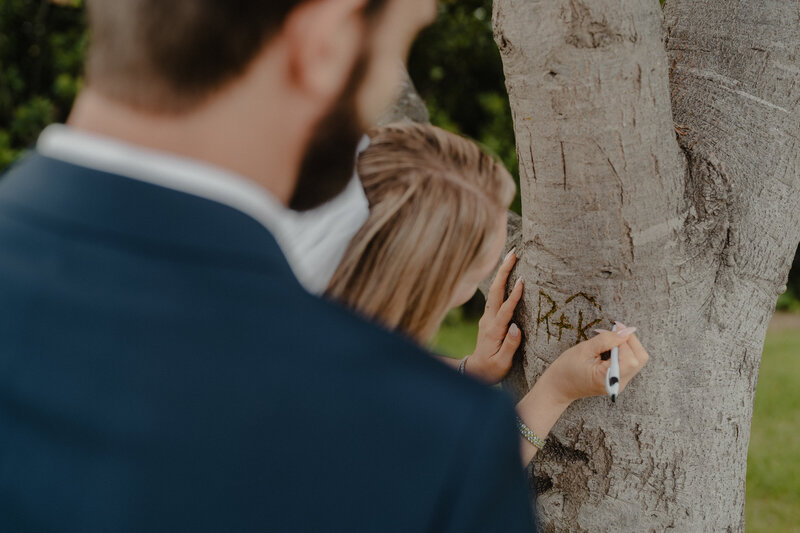 Couple carving their name into a tree in Los Angeles