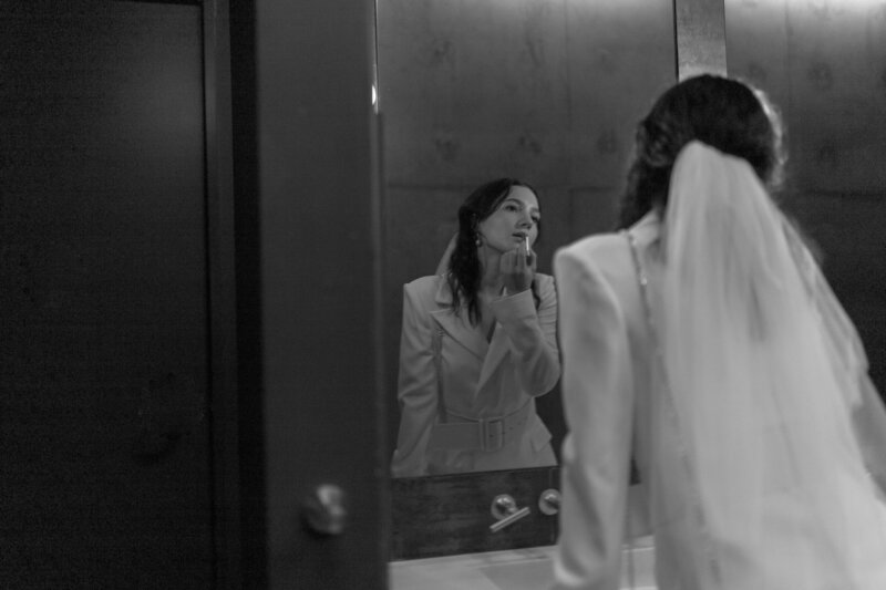 Bride applying lipstick in the mirror at The Jupiter Hotel in Portland, Oregon.