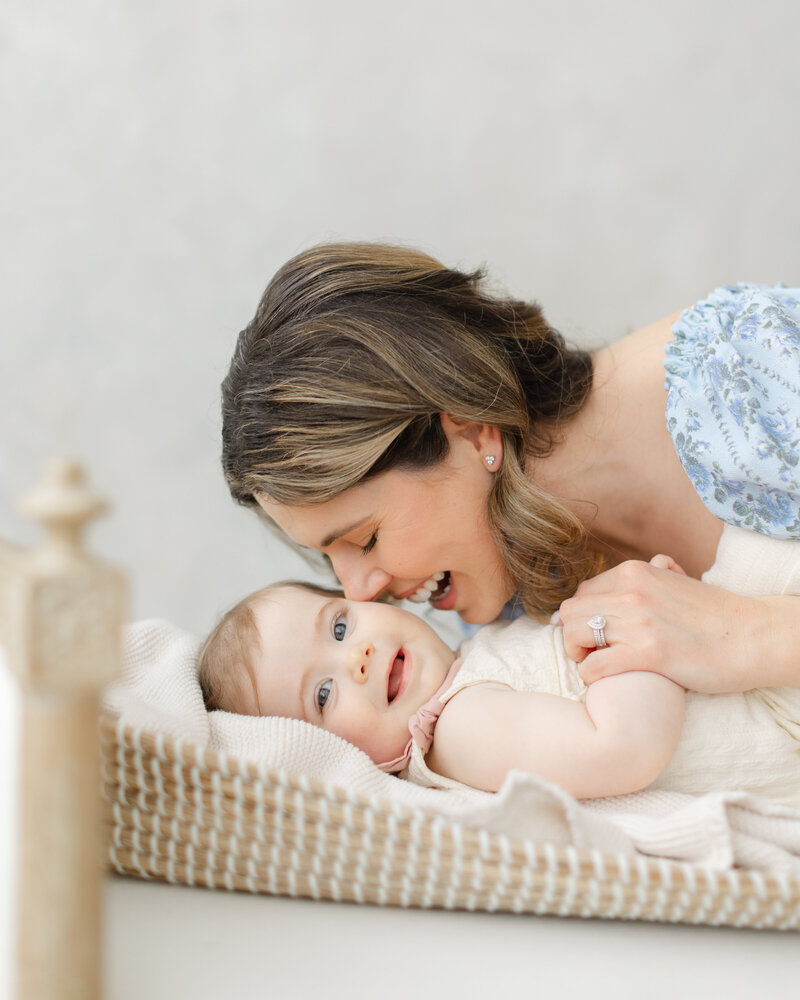 Mother snuggles her 12 month old baby at 12 month milestone portrait session
