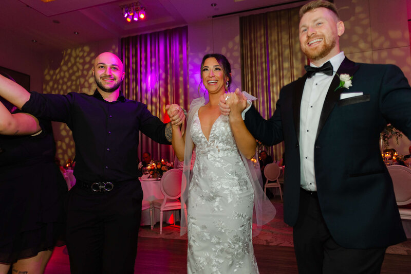 a bride and groom hold hands dancing during their reception.  Captured by Ottawa wedding photographer JEMMAN Photographer