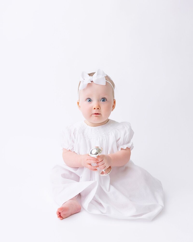 Baby girl in white heirloom gown during newborn photoshoot in Savannah