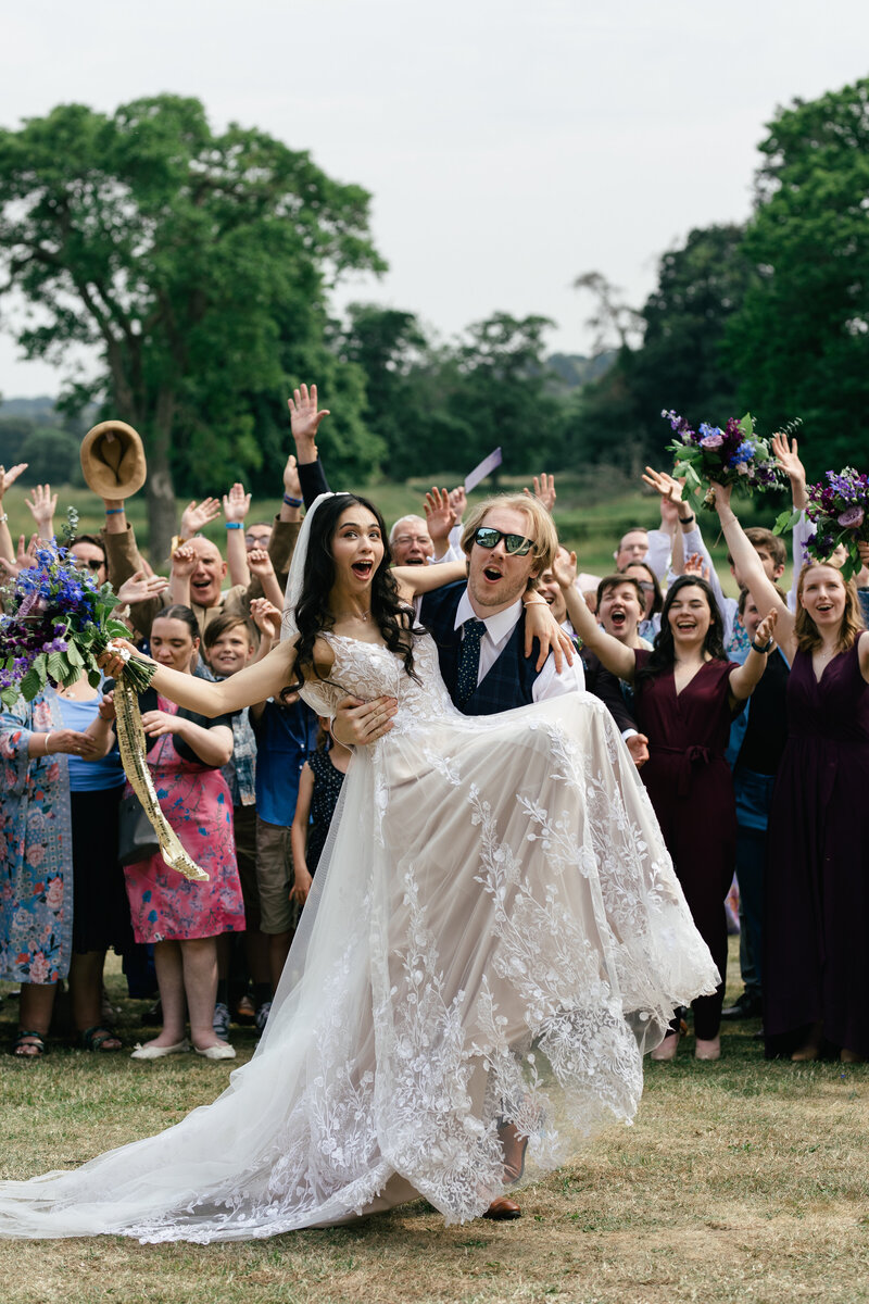 bride and groom celebrate thier wedding with wedding guests during photographs